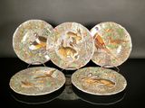 three plates with different designs on them sitting on a table