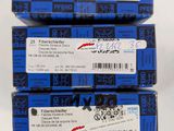 three boxes of blue boxes with white labels on them on a white surface