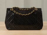 a close up of a black purse on a wooden table