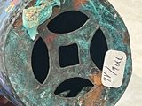 une main tenant un objet métallique muni d'une étiquette