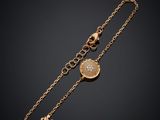 un bracelet plaqué or avec une pièce et une chaîne