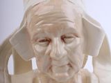 a ceramic bust of a woman with a hat on her head