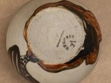 a close up of a white and brown bowl with a bird on it