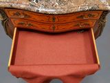 a marble top desk with a drawer underneath it