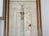 a picture of a wall mounted thermometer with a wooden frame
