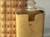 un petit flacon de parfum posé à côté d'une petite boîte