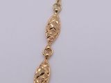 a close up of a gold necklace on a white surface