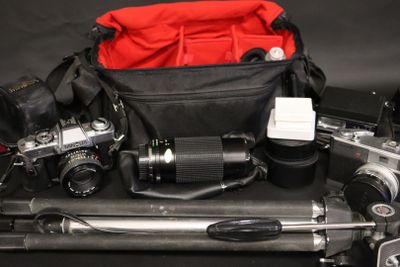 a camera and a camera bag on top of a tripod
