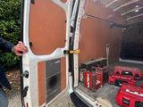 a man that is standing next to a van with tools in it
