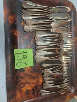 beaucoup de fourchettes et de cuillères sur un plateau, avec une étiquette de prix