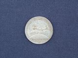 a close up of a silver coin on a blue cloth