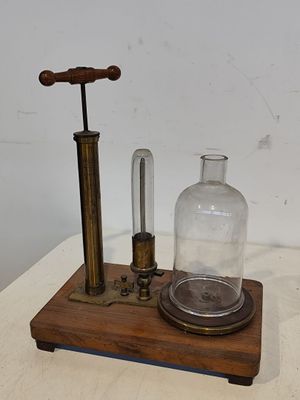 une bouteille en verre posée sur un socle en bois, surmontée d'une autre bouteille en verre