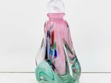a glass bottle that has a pink and blue design on it