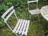 two chairs and a table in the yard