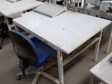 a table with a laptop on it and a chair in front of it