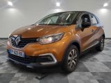 La voiture orange est garée sur un sol à damier dans le garage.