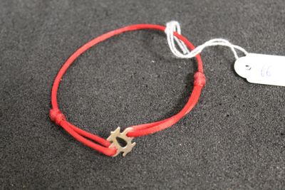 a red string bracelet with a star charm on it