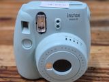 a small blue camera sitting on a wooden table