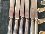 six silverplated knives and six silverplated spoons on a black cloth
