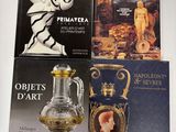 quatre livres posés sur une table avec un vase et un vase