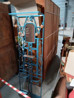 un cadre en fer bleu surmonté d'un miroir