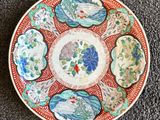 une image représentant une assiette rouge et blanche ornée de fleurs