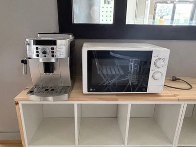 un micro-ondes et une cafetière posés sur une étagère