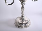 a silver candelab with three candles on it
