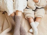 un bébé assis sur un lit avec une peluche
