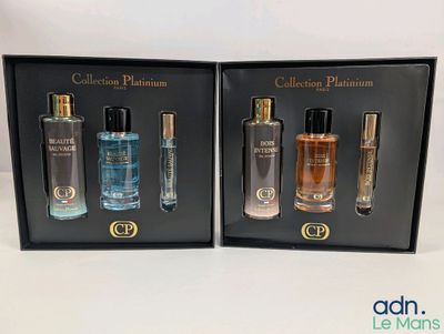 deux flacons de parfum dans un coffret noir posé sur une surface blanche