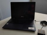 a laptop computer sitting on a table with a charger
