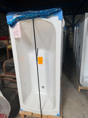 une baignoire blanche posée sur une palette dans un entrepôt