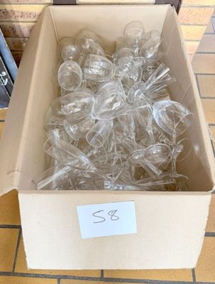 a box full of empty wine glasses sitting on a tiled floor