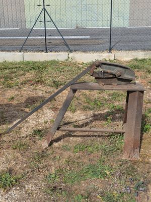 a metal object on the ground next to a fence