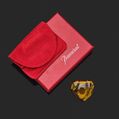 des lunettes de soleil dans un étui rouge et un verre en forme de cœur posé sur une surface noire