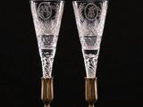 a pair of etched glass champagne flutes on a black background