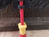 a red and yellow toothbrush sitting next to a black bag