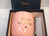 a pink mug that is in a box on a table