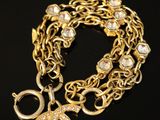un gros plan sur un bracelet à chaîne en or orné d'un pendentif Chanel