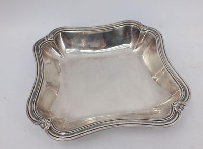 an antique silver plate with a decorative design on it