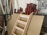 a ladder leaning against a wall next to a pile of tools