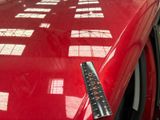 a ruler on the hood of a red car