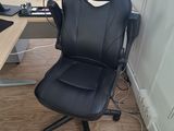 une chaise de bureau noire placée devant un écran d'ordinateur