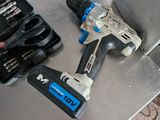a drill and screwdriver sitting on a table next to other tools