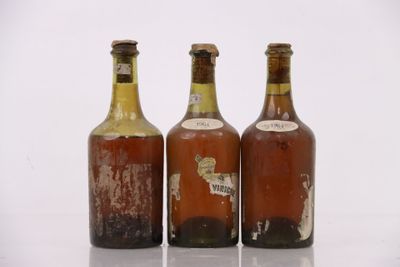 trois bouteilles de bière posées les unes à côté des autres sur une surface blanche