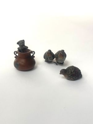 trois oiseaux perchés près d'un vase