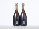 two bottles of wine sitting on top of a table next to each other