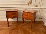 two small tables with marble tops on them on a parquet floor