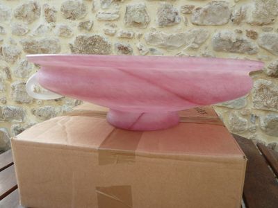 a pink bowl sitting on top of a box on a wooden table