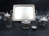 a silver tray and silver tea set on a black table